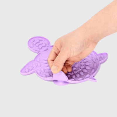 https://cdn.shopify.com/s/files/1/0763/9767/4819/files/Tapis_de_lechage_pour_chien_en_forme_de_tortue_violet.png?v=1749649664